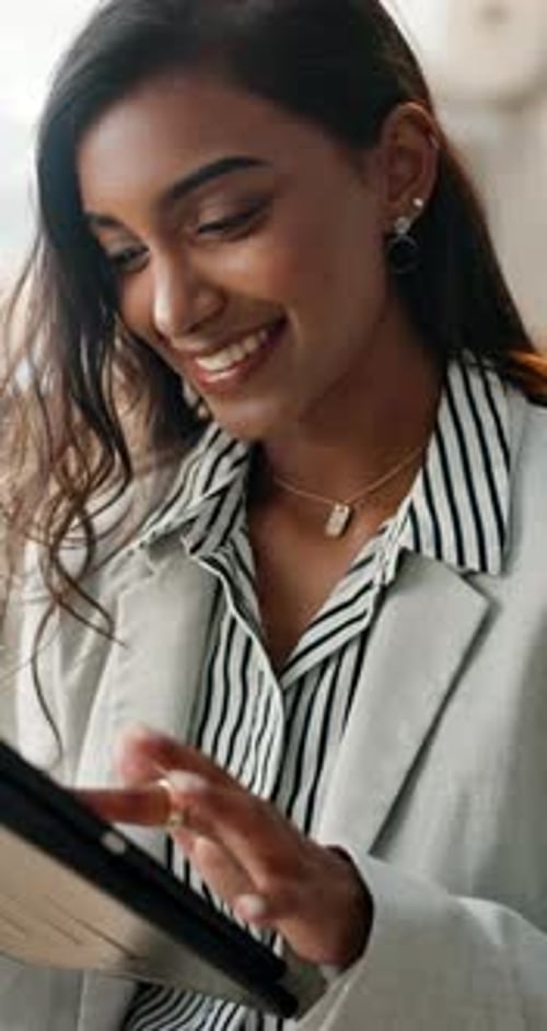 Woman Smiling and Using Tablet in the Office