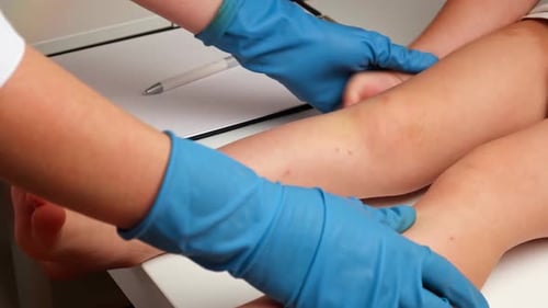 Doctor Examines Child's Leg in Clinic