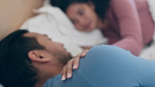 Amor, mãos e casal em uma cama com cuidado, conversa e toque de braço, intimidade