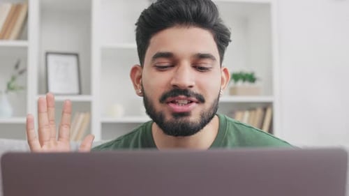 Man Talking on Laptop in Modern Home Setting