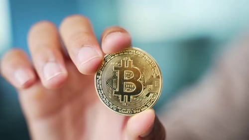 Close up of a man's hand holding a gold bitcoin coin. Rich man holds and shows a gold coin. Cryptocu