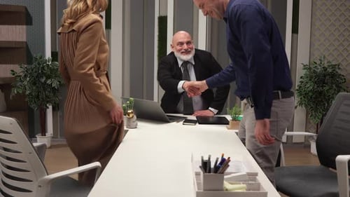 Friendly Smiling Middleaged Caucasian Lawyer Receiving Clients in Modern Office