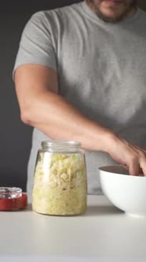 Man Hands Putting Cabbage Into the Fermentation Jar to Prepare Sauerkraut