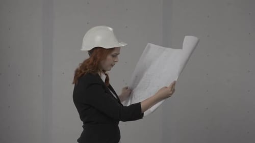 Side View of an Architect Woman Holding a Plan Drawing of a Building in Her Hands A Business Woman