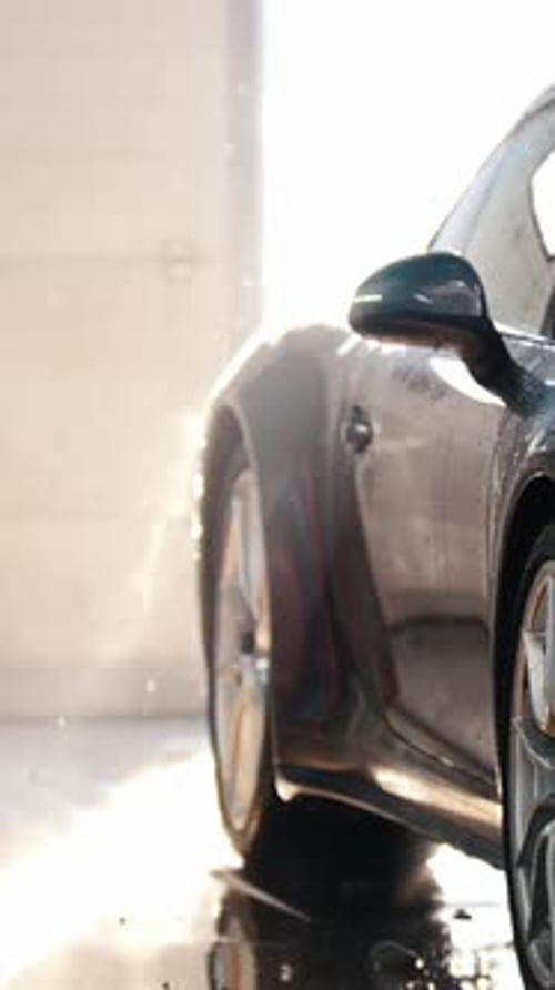 Car Wash Soap Sprayed on Shiny Black Vehicle