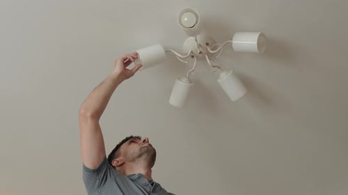 Man Changing Lightbulb on Ceiling Fixture