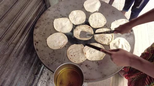 Street Vendor Cooking Flatbreads on Large Griddle