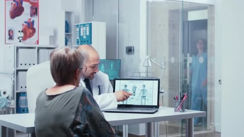 Arzt erklärt dem Patienten das menschliche Skelett