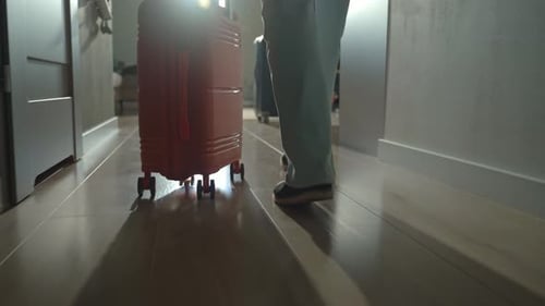 Mulher rola a mala pelo corredor no momento da partida do apartamento