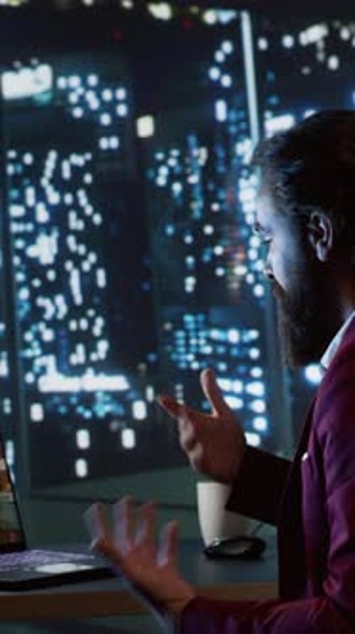 Man on Video Call at Night in City Office