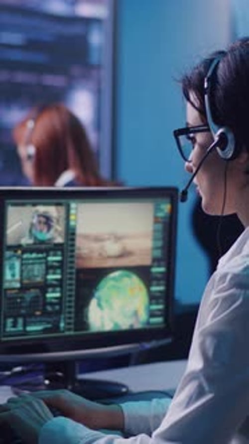 Female Operator Using Computer to Launch Rocket in Office