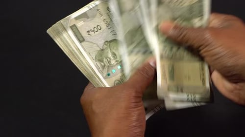 Um homem contando rúpias indianas.