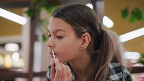 Girl Applying Makeup Indoors with Brush