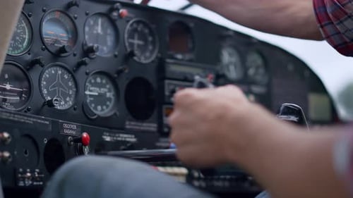Pilot hand checking airplane indicators on control panel preparing for flight