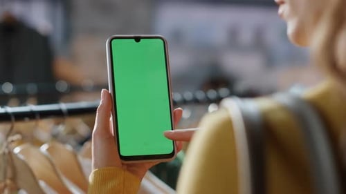 Frau beim Stöbern auf dem Handy im Einkaufszentrum mit den Händen, Nahaufnahme, Shopaholics, das Handy durchsucht