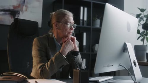 Senior Business Lady Taking Glasses Off and Thinking about Work in Office