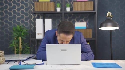 Ill Adult Coughing at Office Desk With Laptop