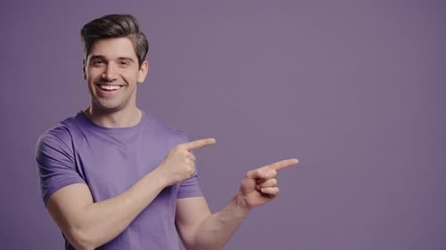 Smiling Man Points to Side on Purple Background