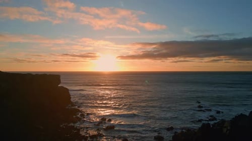 Picturesque sunset over calm sea coastline dark mountain silhouette drone view