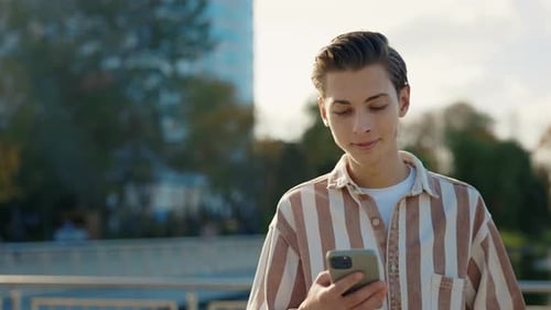 Young Man Walking on the Street Using His Smartphone Texting with Friends Smile Internet Face
