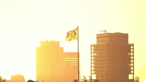 Buildings and Flag Waving at Sunrise