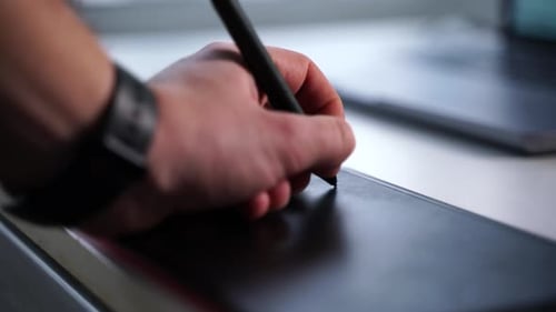 Hand Using Stylus on Graphic Design Tablet