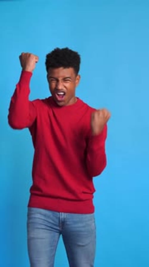 Man Celebrating Success Against a Blue Background