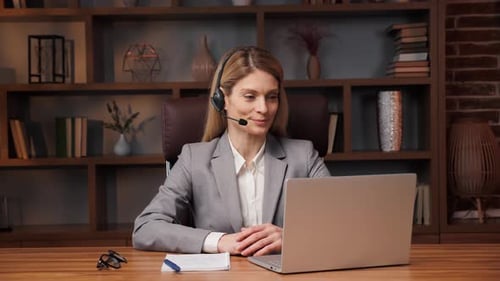 Smiling Young Confident Business Woman in Headset Make Conference Call in Office