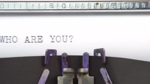 Who Are You phrase closeup being typing and centered on a sheet of paper on old vintage typewriter
