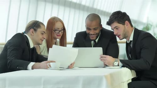 Business Team Meeting at a Table Looking at Documents