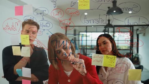 Brainstorming Team Drawing Graph on Glass Board