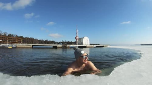 Man Swimming in Ice Water on Sunny Day