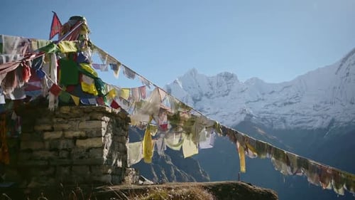 Banderas de oración budistas y montañas de Nepal, banderas de oración tibetanas en el cielo azul, un día soleado bajo la capa de nieve