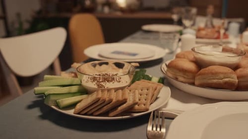 Hummus and Sufganiyot on Table for Hanukkah Dinner at Jewish Family Home