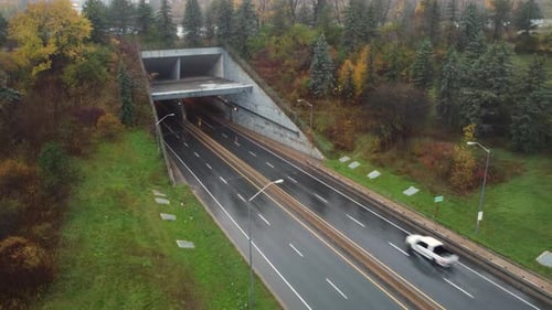 Aerial view over vehicles driving through rainy underground highway tunnel entrance in Niagara regio