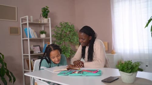 Girl Doing Homework with Help from Woman
