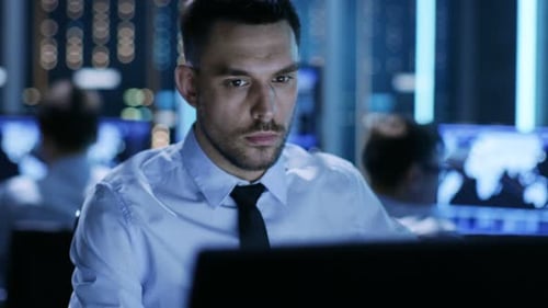 Primer plano de un controlador técnico profesional sentado en su escritorio con varias pantallas ante H