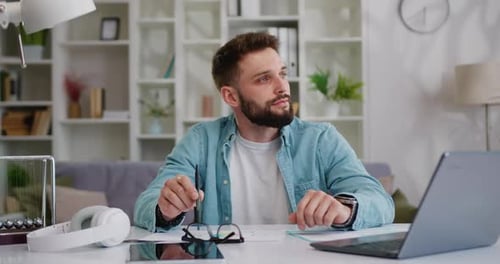 Man Thinking at Desk in Bright Home Office