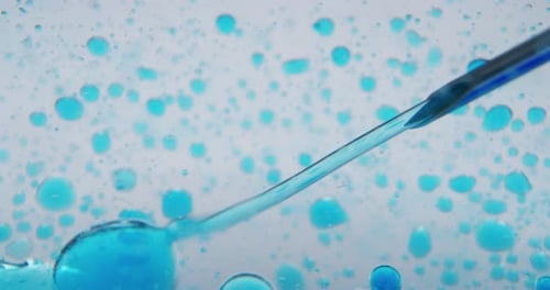 Slow motion macro of micro particles molecules in a liquid are analyzed with microscope for bioche