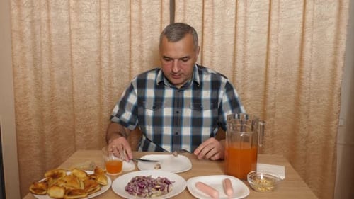 Man Eating a Variety of Food at Table