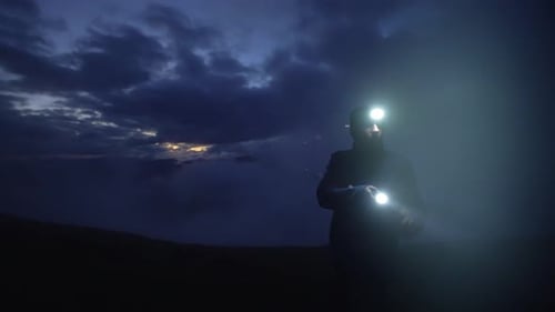 Man with Headlamp in Dark and Stormy Outdoors