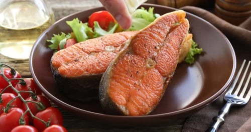 Salmon Steaks Garnished with Lemon and Fresh Salad