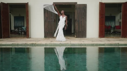 Nonbinary Black Person Model Poses in White Dress at Luxury Villa Entrance By Swimming Pool Gay