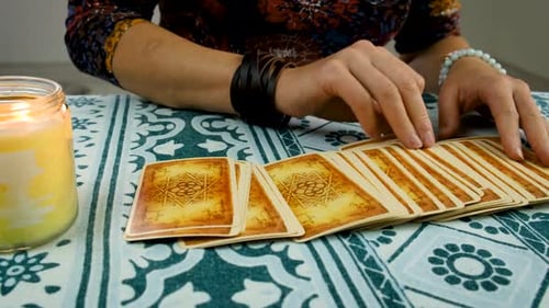 Woman Shuffles Tarot Cards by Candlelight