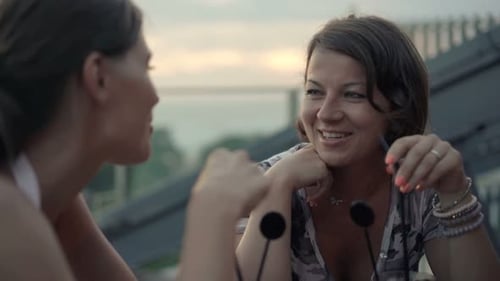 Happy, Pretty Girlfriends Talking and Drinking Beverages in Cafe Adult