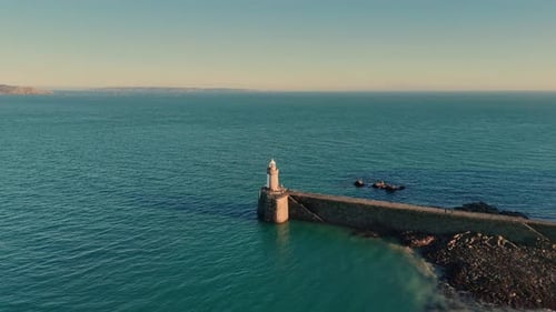 High circling drone footage of leading light on Castle Cornet breakwater at the entrance to St Peter