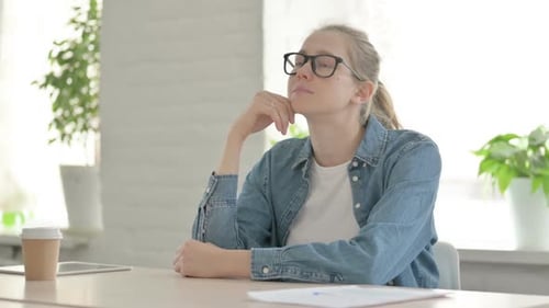 Pensive Young Woman Thinking While Sitting in Office