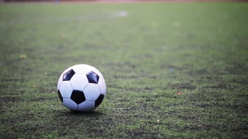 Soccer player practices kicking the ball on a green field for football training