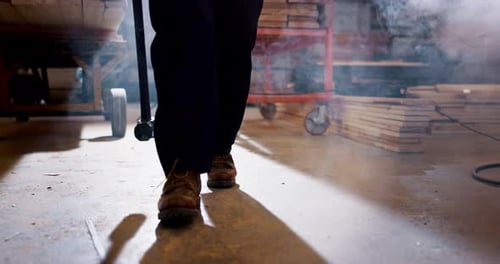 Worker, tool and person with hammer walking in workshop with smoke or dust from construction
