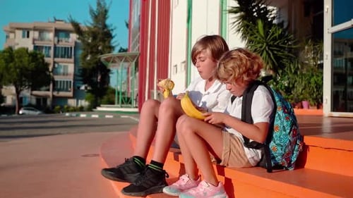 Students Eating Lunch in School Yard During Break Sitting on the Porch